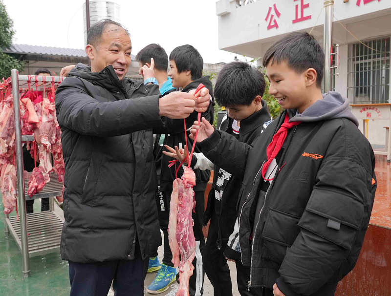 一名老师在给获奖学生发猪肉(梁秀明/图)据悉,知了小学自2018年秋季