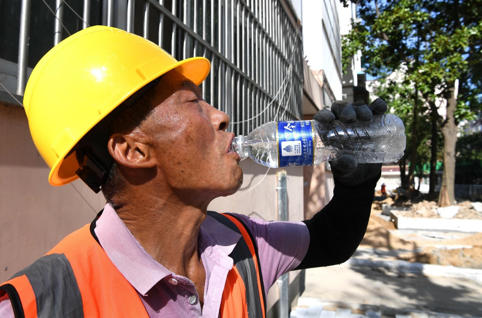 建筑工人在工作间隙喝水解渴